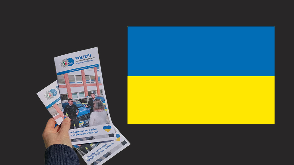 Zwei Flyer auf ukrainisch auf der linken Seite. Die ukrainische Flagge rechts im Bild. 