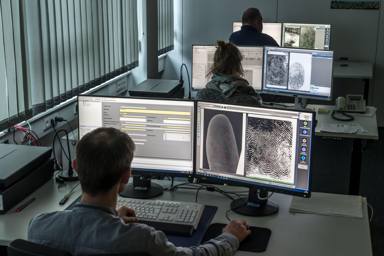 Drei Auswerter sitzen am Computer und betrachten Fingerabdrücke