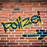 Polizei Graffiti auf roter Mauer