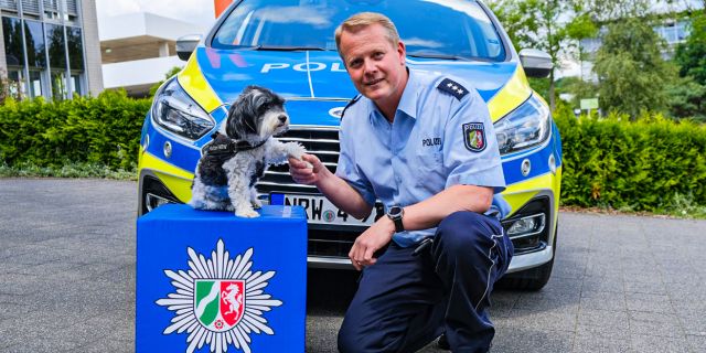 Opferschutzhund Summer gibt einem Polizisten Pfötchen
