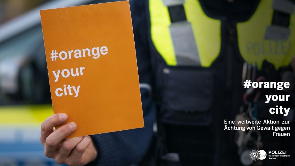 Ein Hand hält eine Karte mit der Aufschrift "Orange your City"