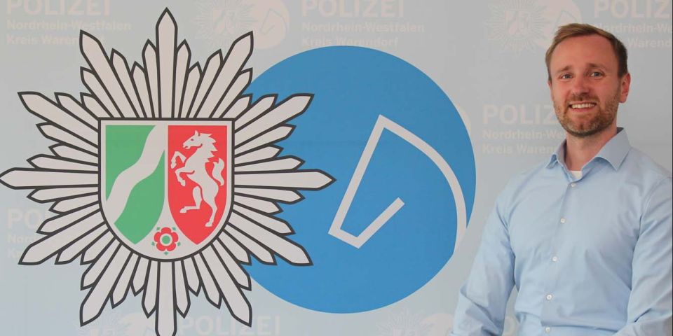 links Polizeistern, mittig runder Kreis mit stilisiertem Pferdekopf, rechter Bildrand Jonas Dues